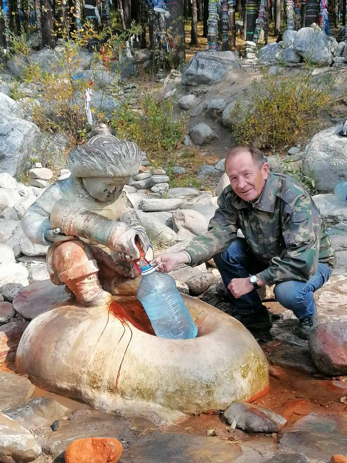 Владимир Медведев набирает воду у источника в Аршане